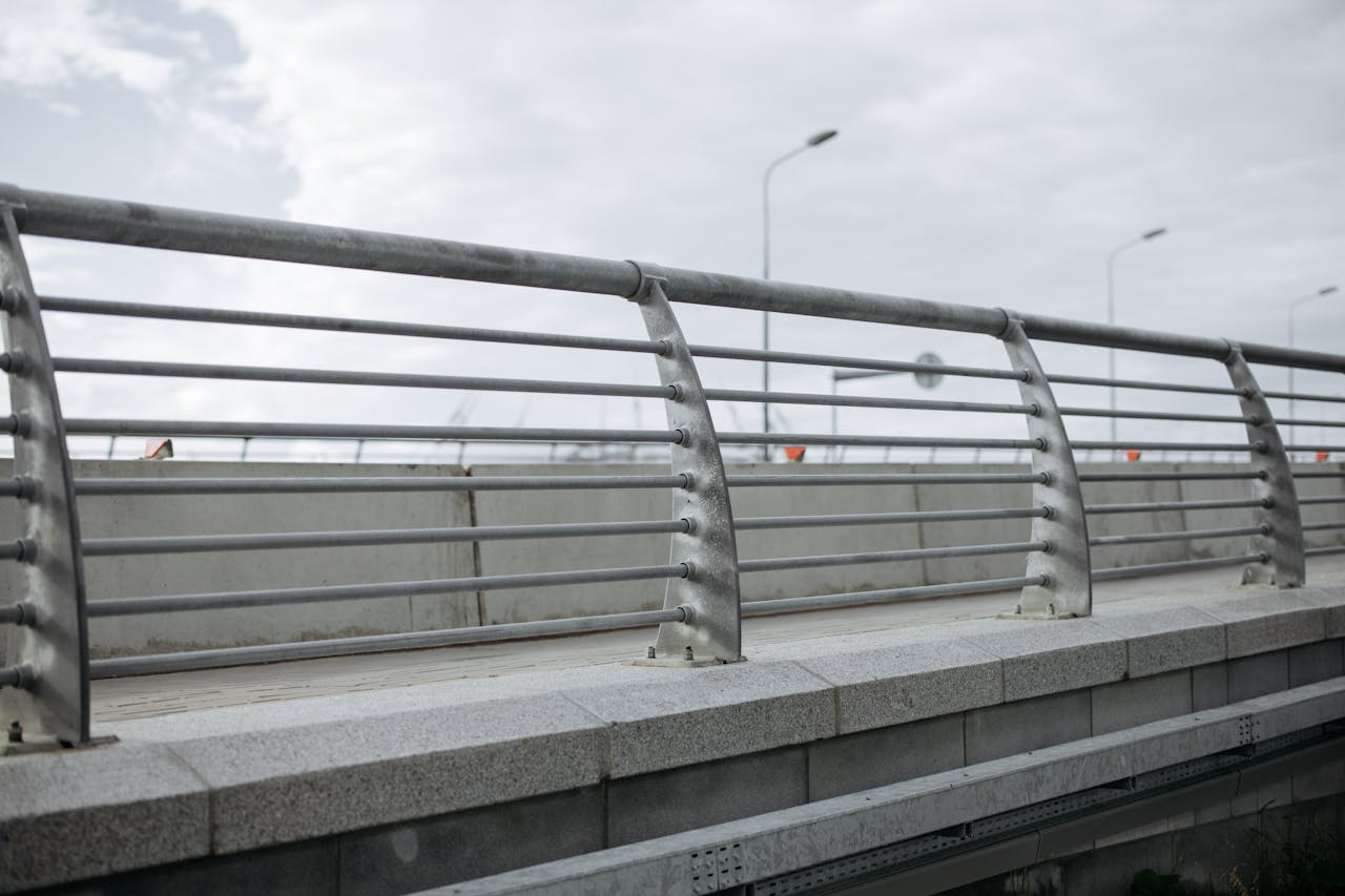 Maîtriser la première impression : Votre titre d’article intrigant ici A modern bridge featuring concrete and metal railings under a cloudy sky.